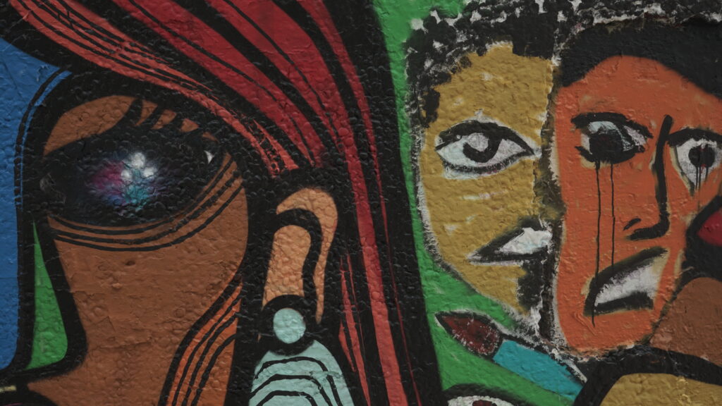 partie d 'une peinture murale visages d'unefemme et 2 hommes, couleurs vives